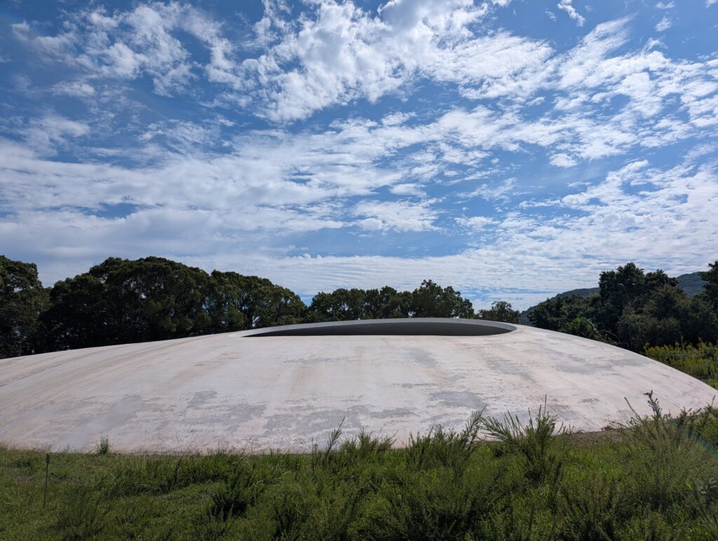 草地の向こうの、白い水滴のような豊島美術館の建物