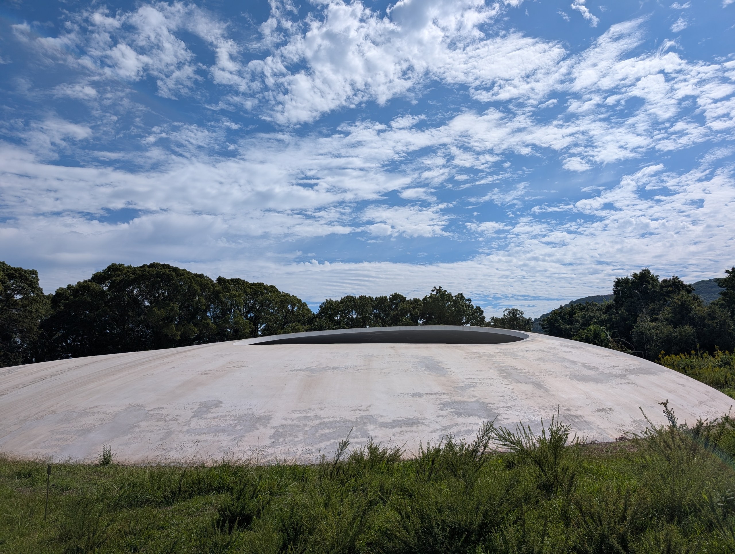 草地の向こうの、白い水滴のような豊島美術館の建物