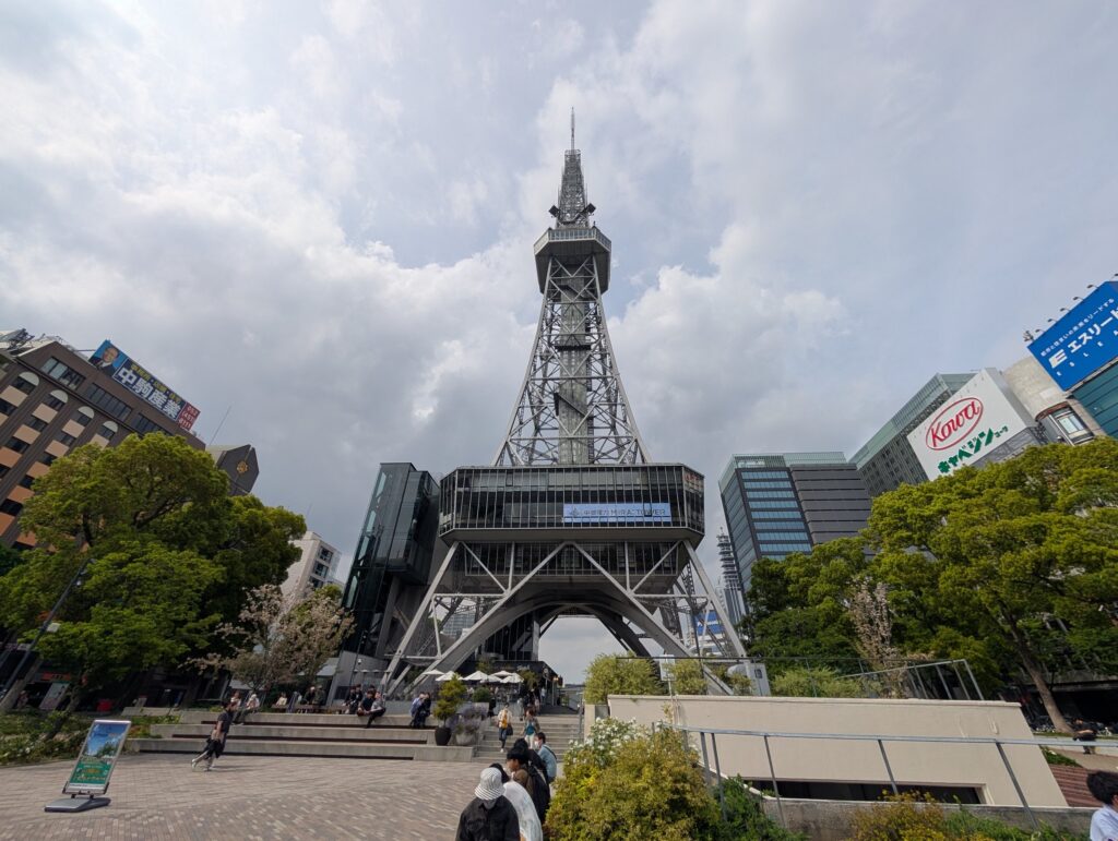 曇り空の下にそびえる中部電力 MIRAI TOWERと、足もとの公園