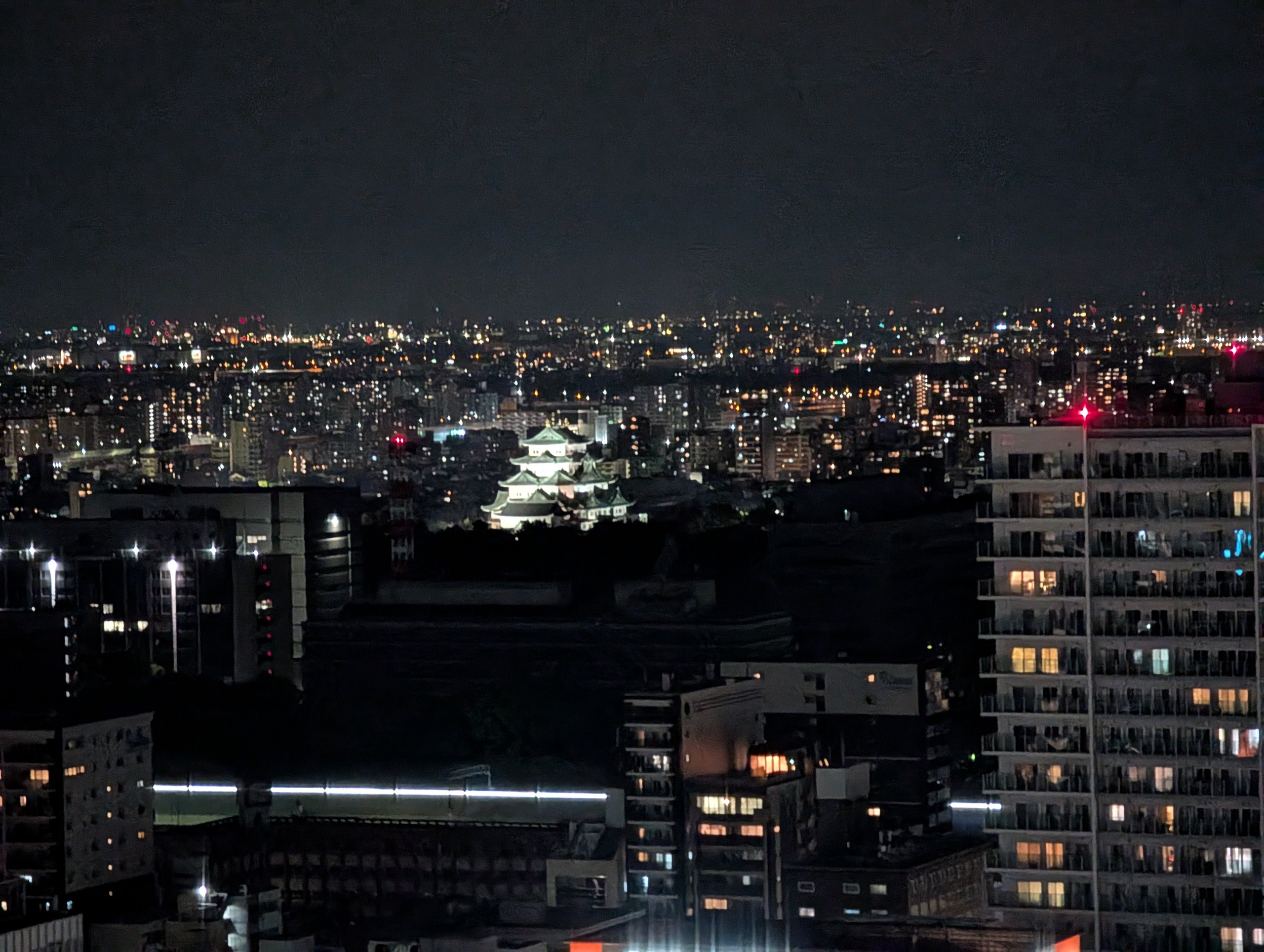 遠くにライトアップされたお城が見える夜景