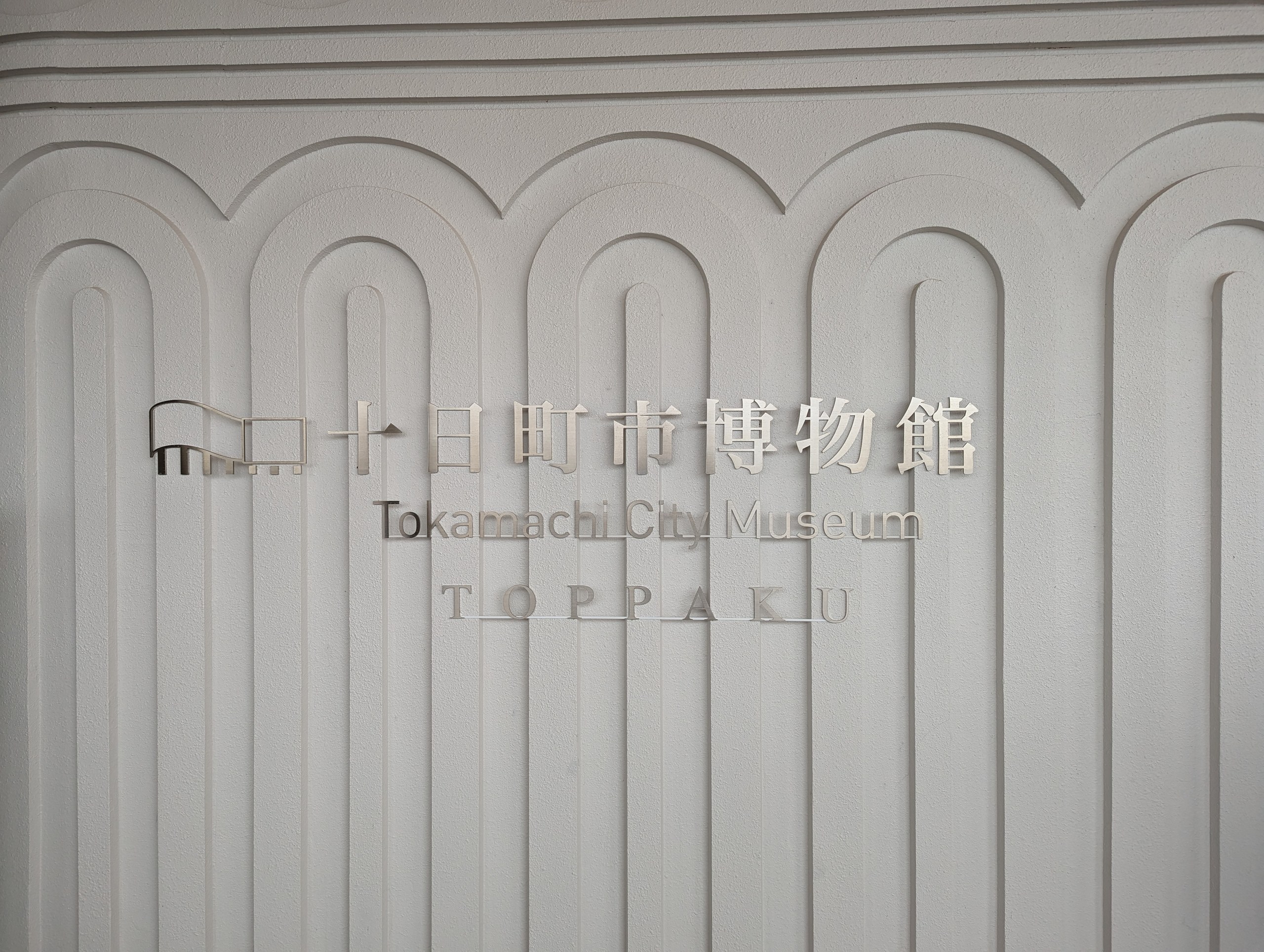 「十日町市博物館 TOPPAKU」の文字が入った白い壁