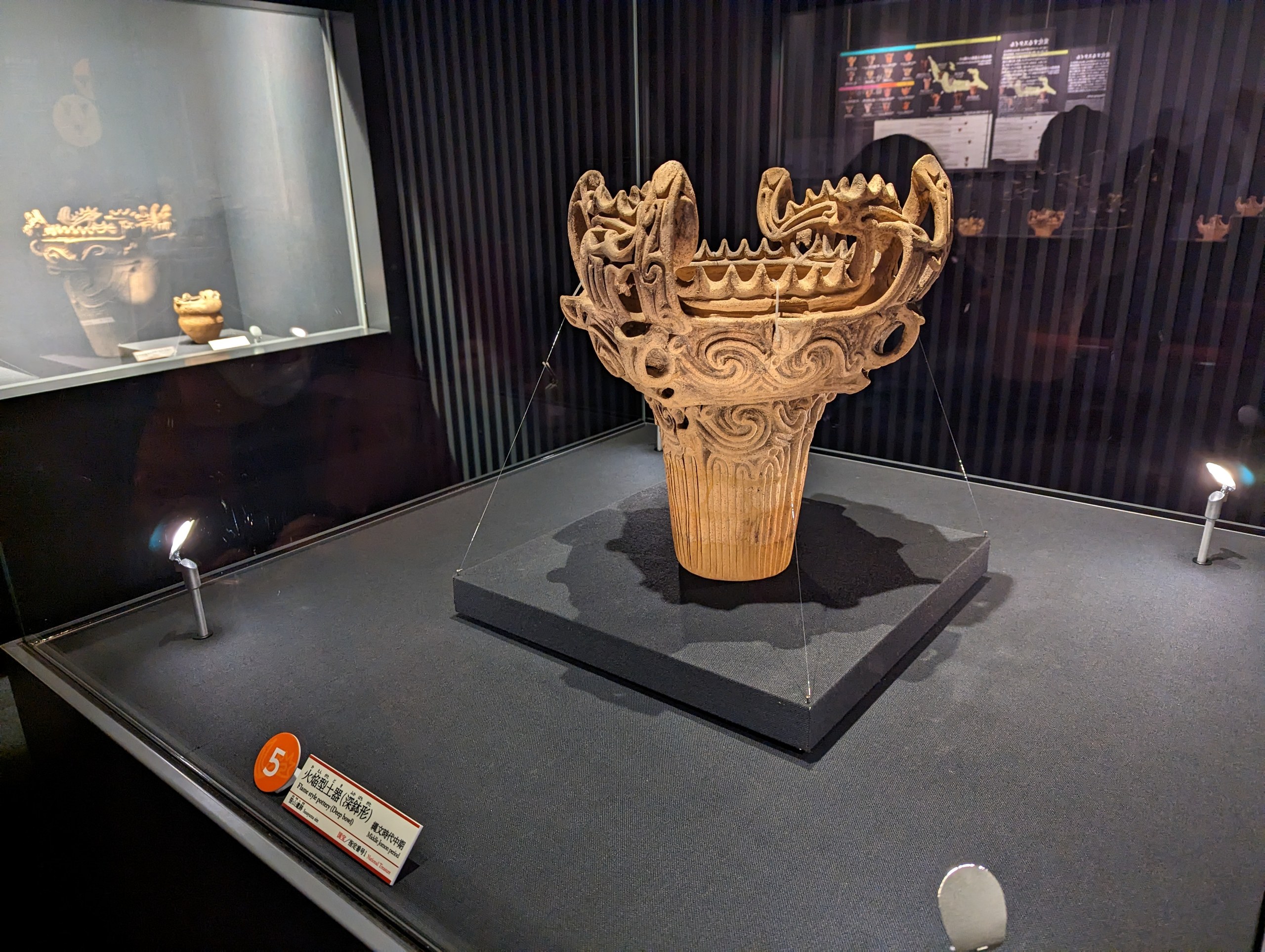展示台の上に照らされた、炎のような飾りの火焔型土器