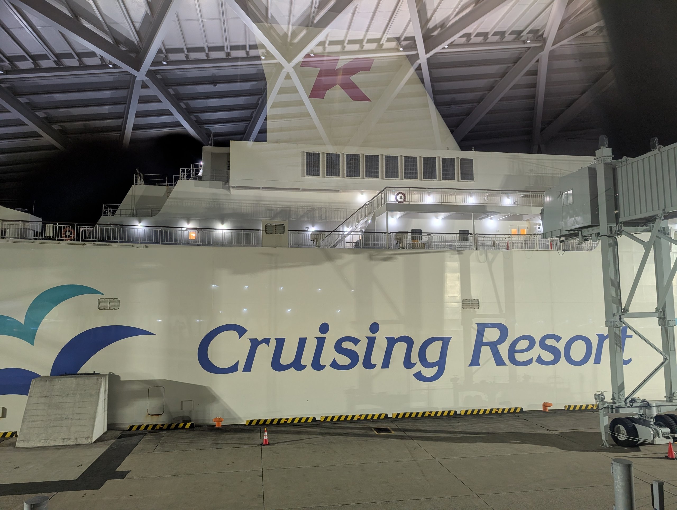 「Cruising Resort」と書かれた白い船体と、乗船口へ続く通路