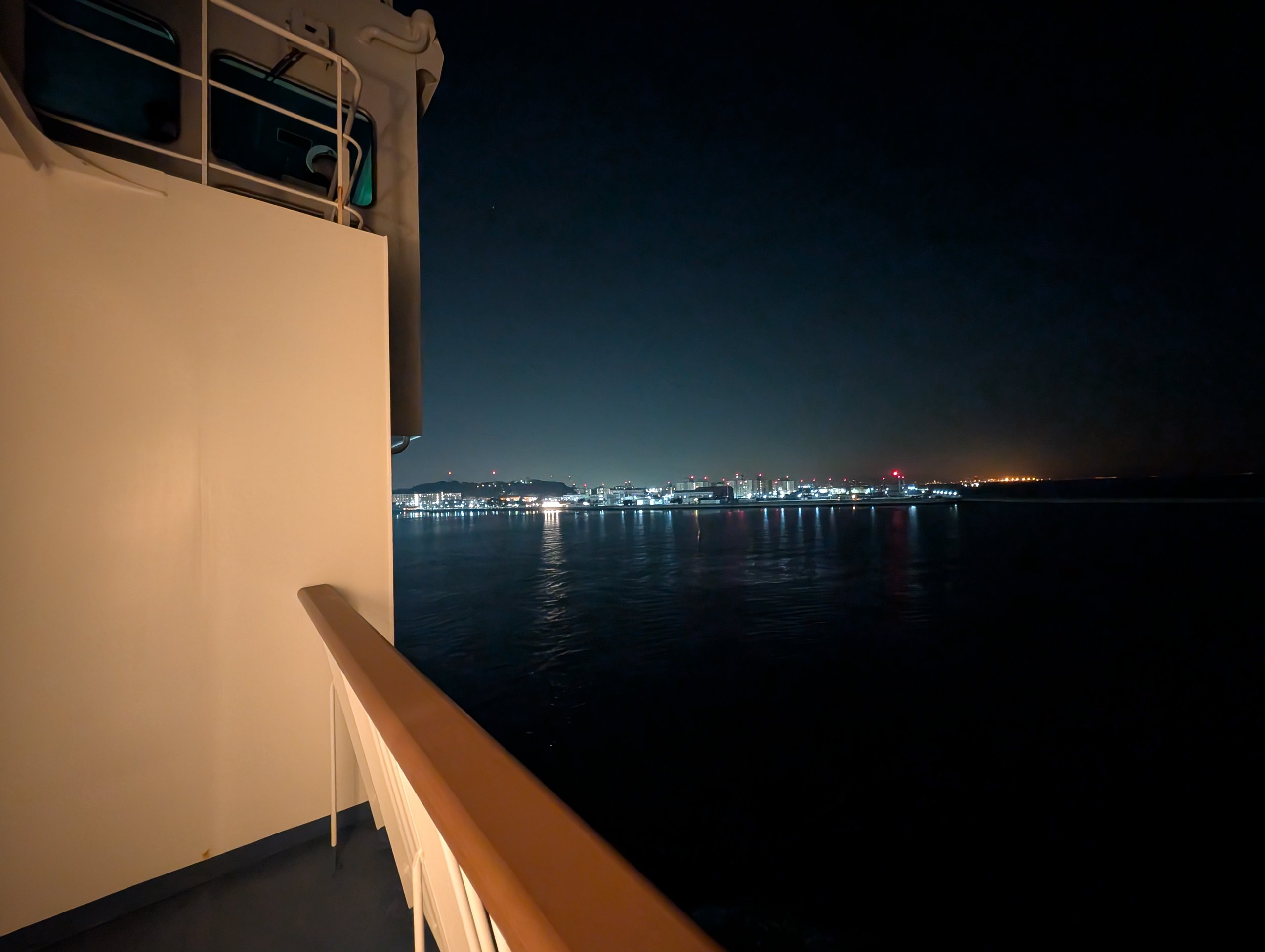 夜の海の向こうに見える街の明かり
