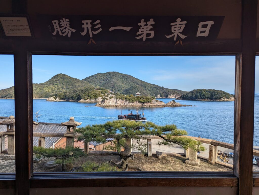 「日東第一形勝」の額の下、窓の向こうに広がる海と島