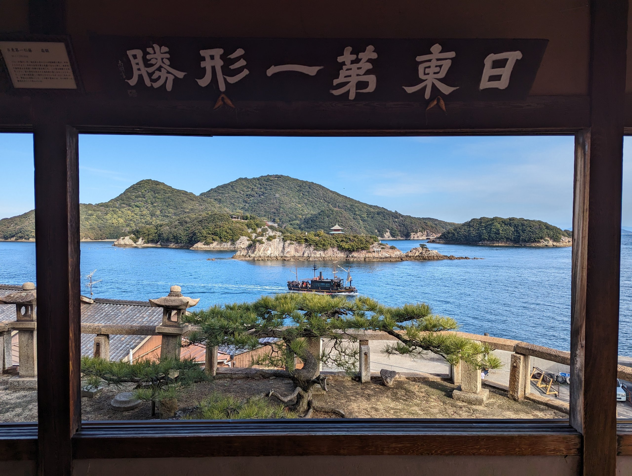 「日東第一形勝」の額の下、窓の向こうに広がる海と島