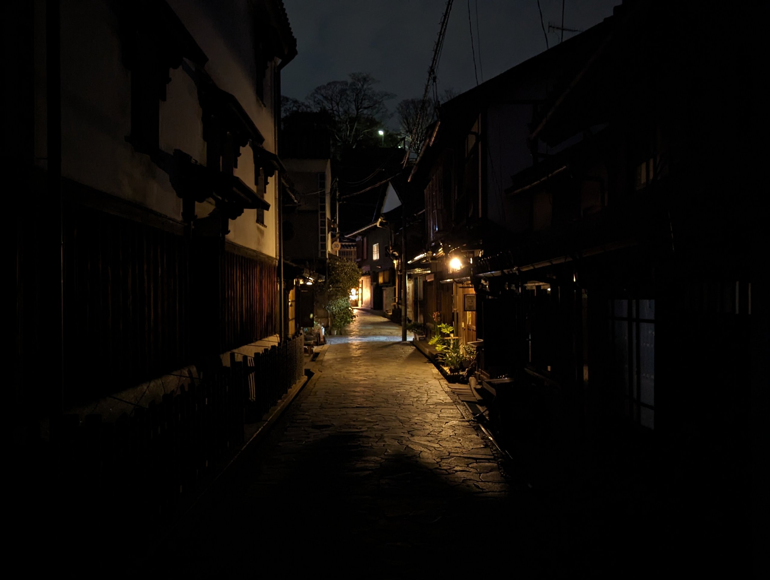 家の灯りがこぼれる、夜の細い路地
