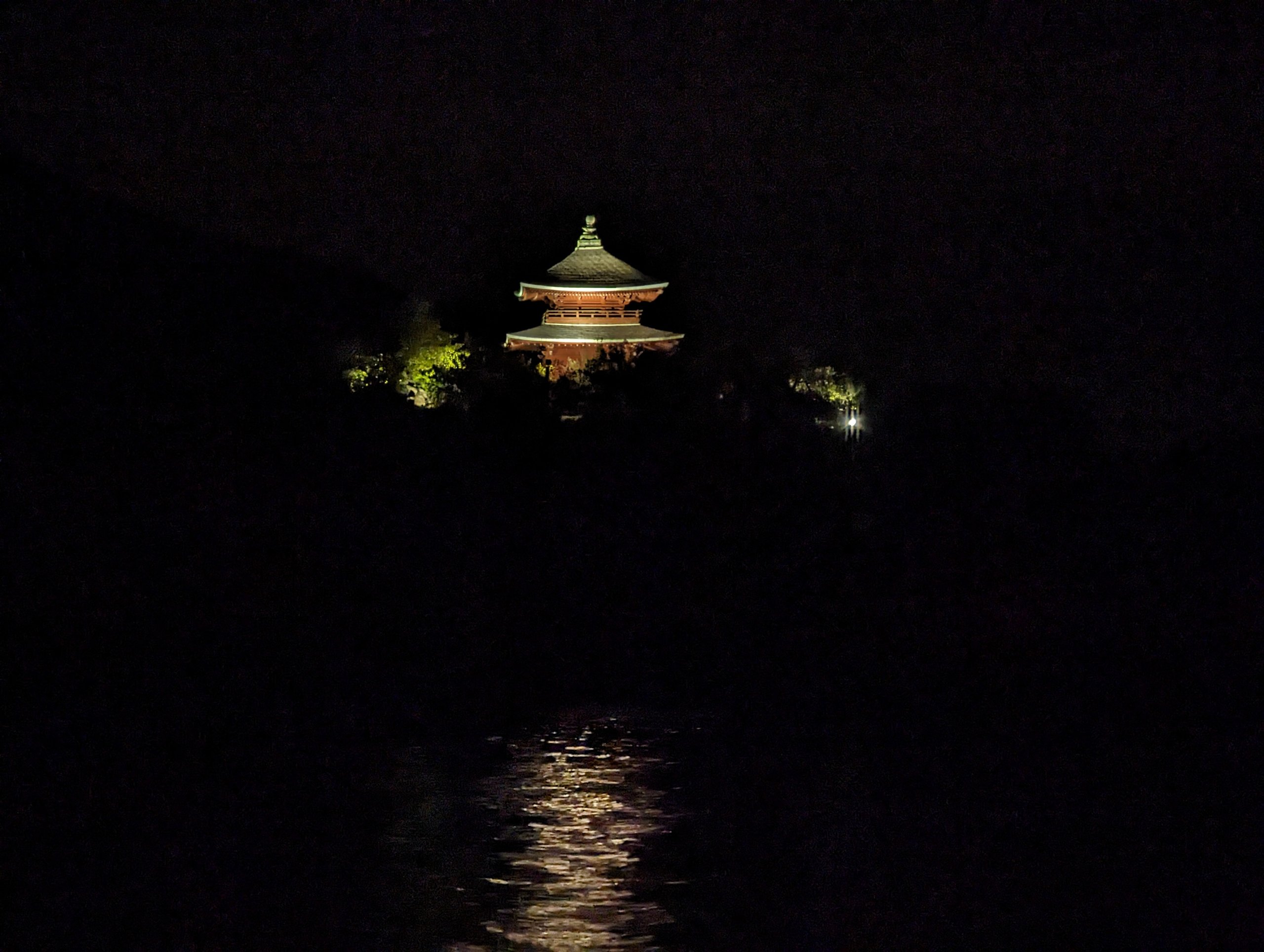 暗い海の向こうに、ライトアップされたお堂が浮かぶ