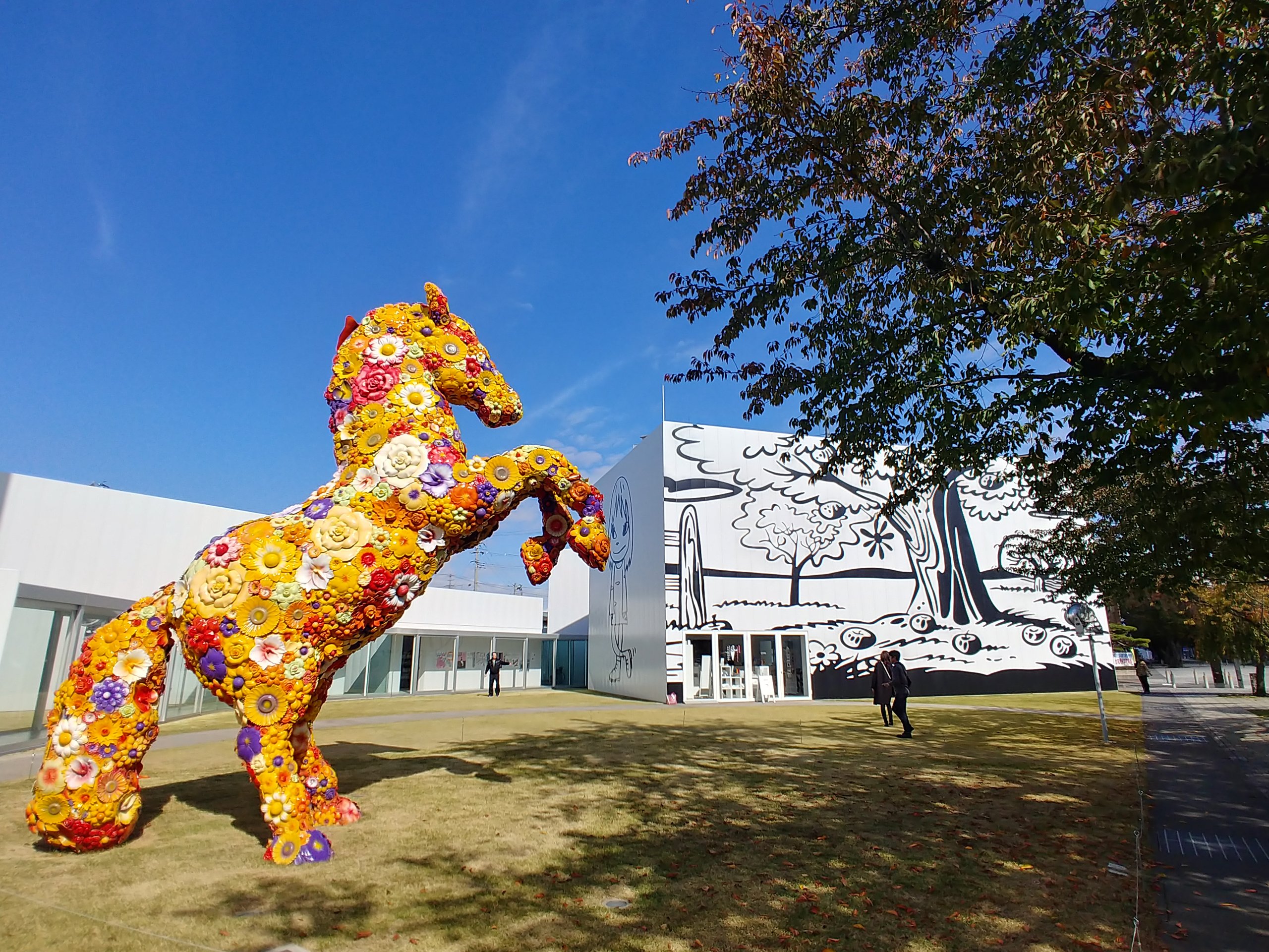十和田市現代美術館の前に立つ、花で覆われた馬の作品「フラワー・ホース」