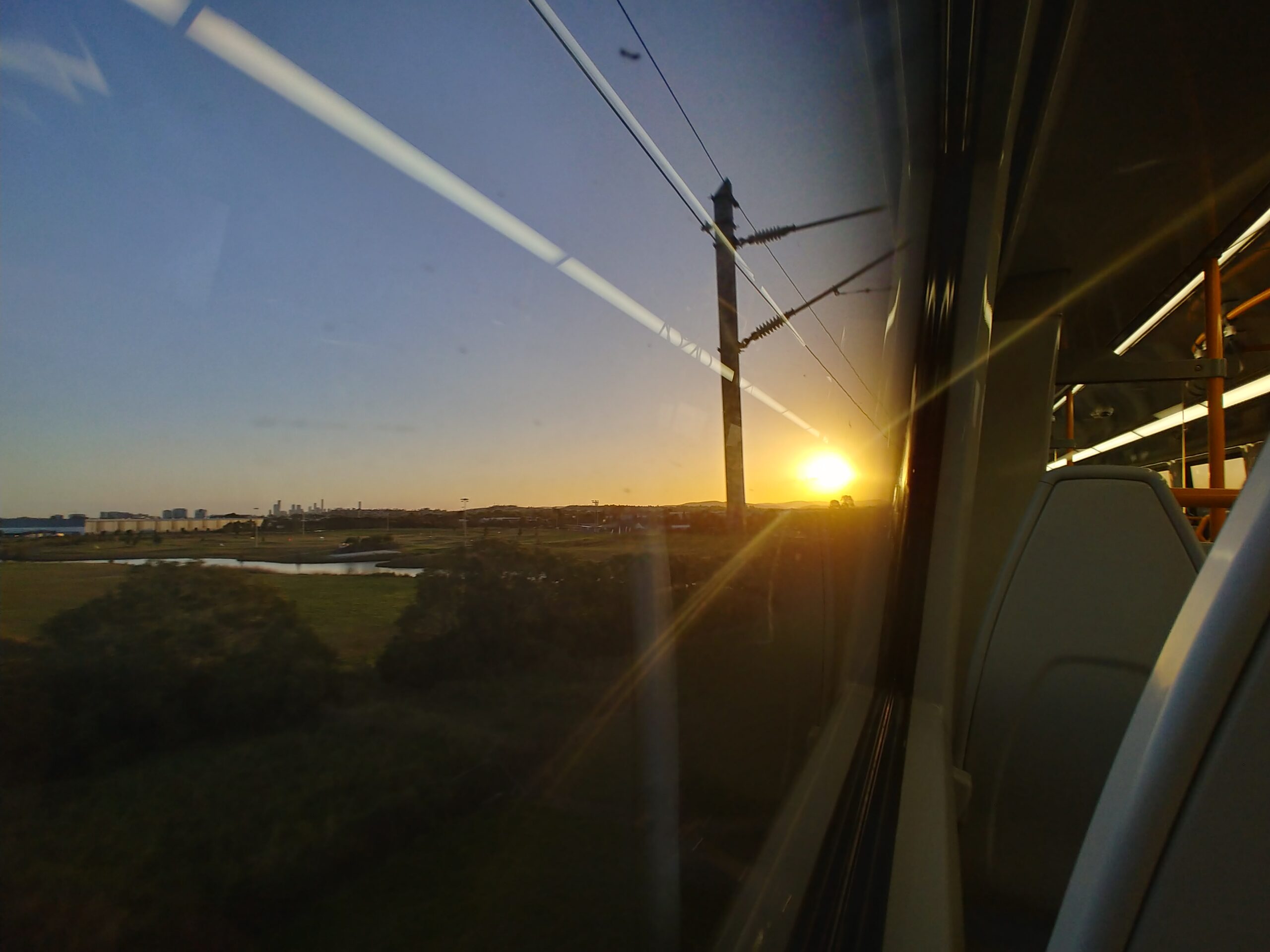 列車の窓から見た、ブリスベン近郊の夕日