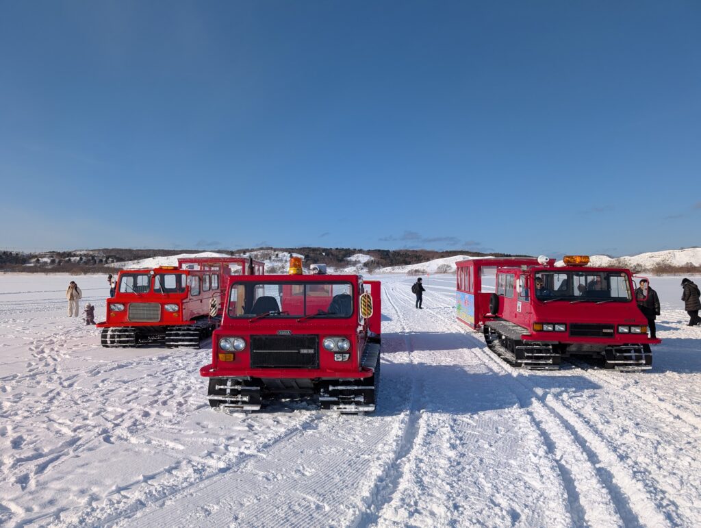 凍った沼の上に並ぶ、赤い雪上車