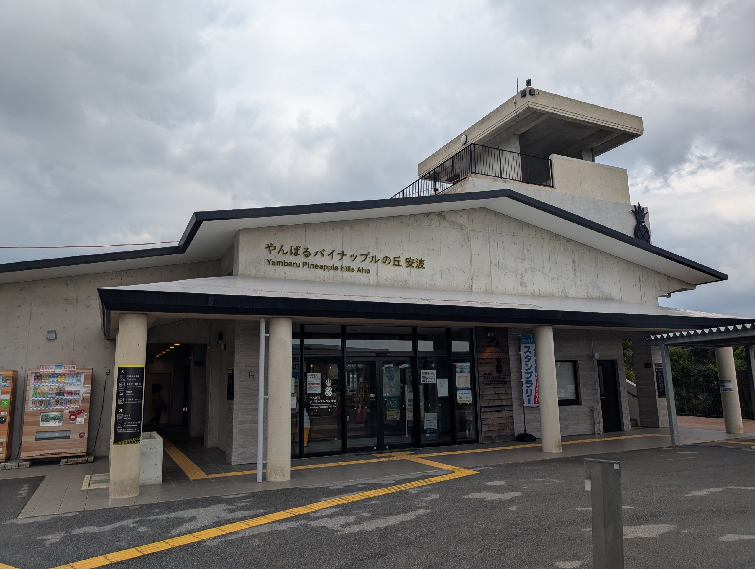 曇り空の下の「やんばるパイナップルの丘 安波」の建物と看板