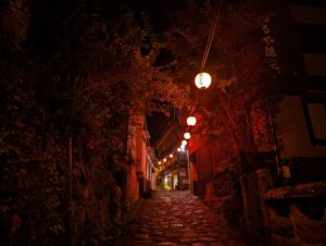 赤い提灯が灯る、夜の石畳の路地