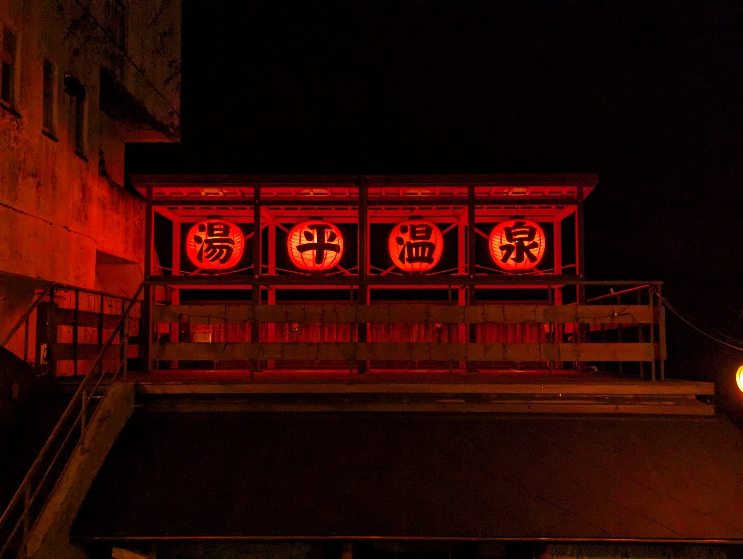 「湯平温泉」の赤い文字が光る、夜の看板